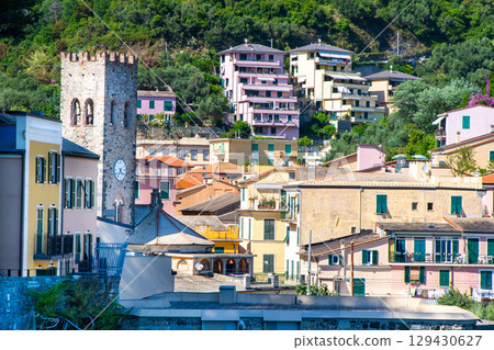 Bell ringer in Monterosso, Cinque Terre. Clock on the church tower. Colorful houses buildings Italian village narrow street old architecture Italy 129430627