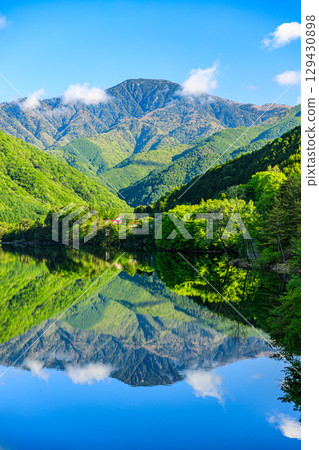 Lake Hirose, with its beautiful mountain ranges and tranquil greenery reflected on its surface 129430898