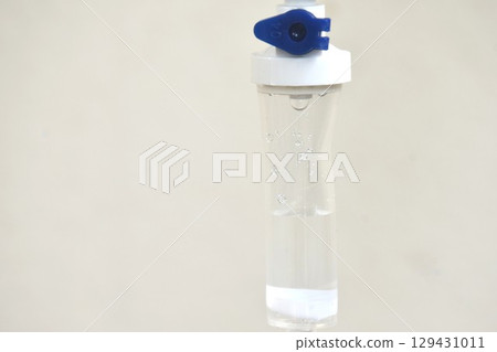 saline solution dropping and flowing to rubber tube on white background 129431011