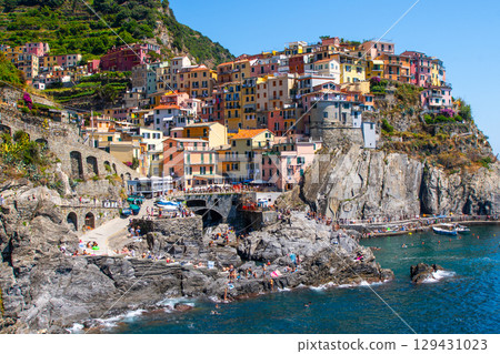 Multicolor houses building on cliff edge. Manarola Italian village Cinque Terre, Liguria, Italy. Summer Multicolor houses building on cliff edge. Manarola Italian village Cinque Terre, Liguria, Italy. Summer 129431023