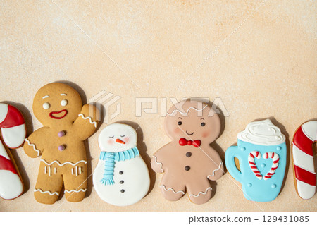 Gingerbread cookies with icing decoration. Christmas food. Gingerbread man snowman baking. Top view table. Xmas sweet copy space background 129431085
