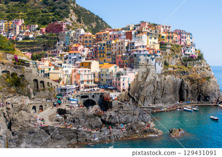 Colorful houses on cliff edge. Manarola Italian village Cinque Terre, Liguria, Italy. Summer sea 129431091