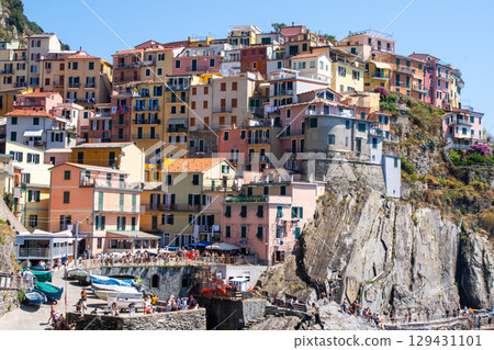 Multicolor houses building on cliff edge. Manarola Italian village Cinque Terre, Liguria, Italy. Summer Multicolor houses building on cliff edge. Manarola Italian village Cinque Terre, Liguria, Italy. Summer 129431101