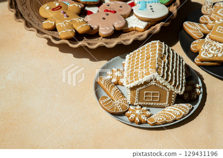 Decorated Gingerbread House and Cookies on table. Christmas food baking. Xmas sweets 129431196