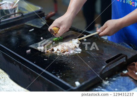 Grilled squid on a sizzling plate – a delicious street food 129431237