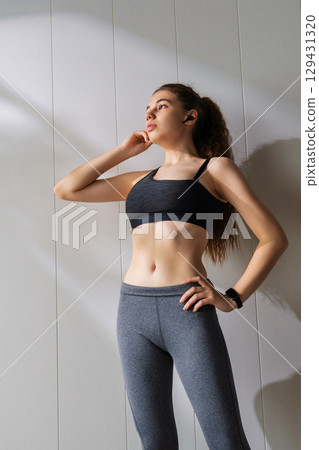 Woman in fashionable sportswear is doing exercise. 129431320