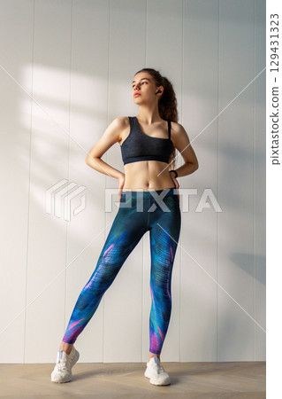Woman in fashionable sportswear is doing exercise. 129431323