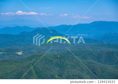 Paraglider flying in the summer sky Paraglider flying in the summer sky 129431633