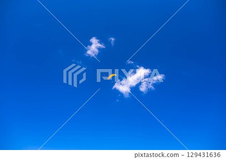 滑翔傘在夏日藍天中飛翔 129431636