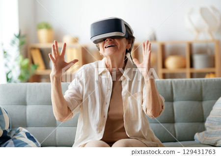 woman playing console games wearing vr goggles 129431763