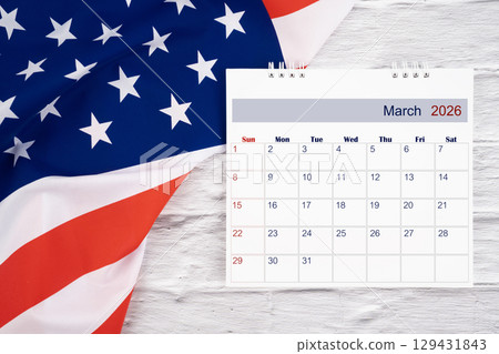 March 2026 Monthly desk calendar and United States of America flag, Flat lay. March 2026 Monthly desk calendar and United States of America flag, Flat lay. 129431843