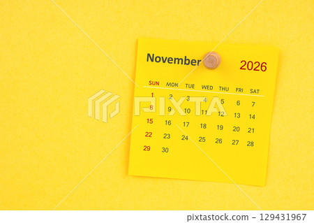 November 2026 calendar sheet with thumbtack on yellow color background. 129431967