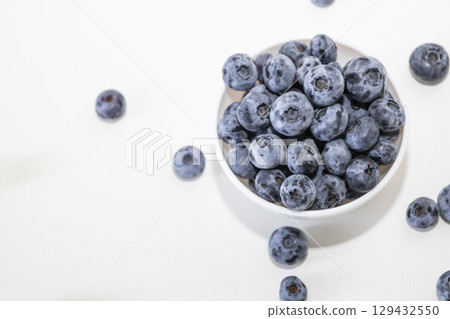 Blueberry is tasty, healthy and delicious fruits. Fresh blueberries heap in white bowl. Wild blueberries in plate with copy space for background. Blueberry is tasty, healthy and delicious fruits. Fresh blueberries heap in white bowl. Wild blueberries in plate with copy space for background. 129432550