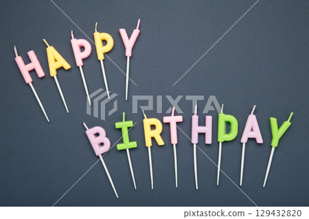 Happy birthday candles on dark blue background Happy birthday candles on dark blue background 129432820