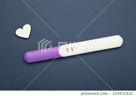 Pregnancy test with positive pregnant on dark blue background. 129432822