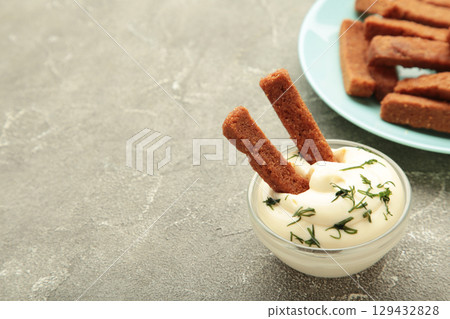Rye rusks with garlic. Garlik bread snack for beer. Rye bread croutons with garlic sauce on grey concrete. Top view Rye rusks with garlic. Garlik bread snack for beer. Rye bread croutons with garlic sauce on grey concrete. Top view 129432828