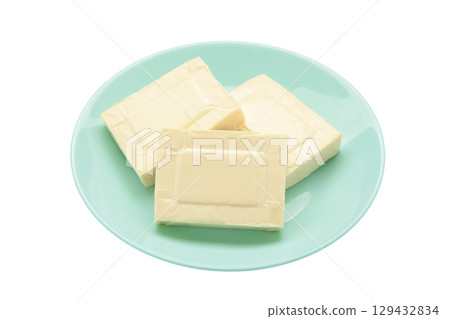 Processed cheese in foil on plate isolated on white background 129432834