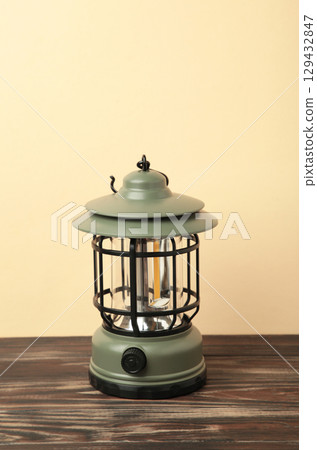 One lantern lamp on beige background. Camping. Vertical photo 129432847