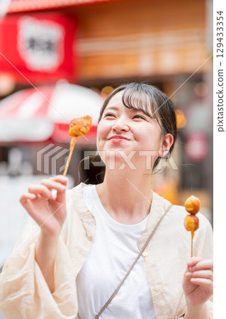 大阪府大阪市道頓堀，一名女子在戶外享用炸串 129433354