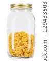 Dried macaroni cockerel scallops. Pasta in a glass jar isolated on a white background. 129433503