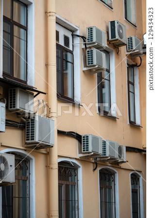 Facade of building with many air conditioners on windows in southern hot country. Escape from heat 129434323