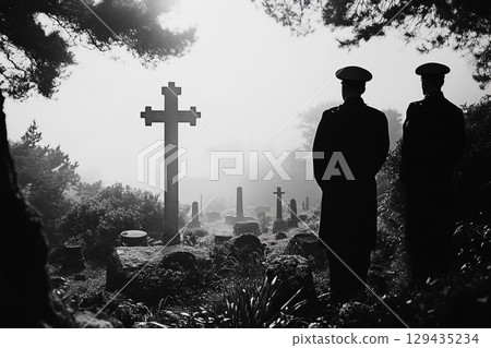 Military soldiers pay tribute in a somber military cemetery during a foggy morning 129435234