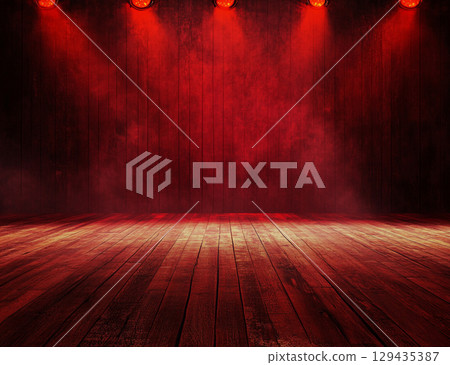 A dimly lit wooden stage is bathed in dramatic, hazy red light from above, creating an empty yet powerful and theatrical atmosphere. 129435387