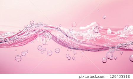 A vibrant splash of clear water creates a dynamic wave and delicate droplets on a calm, reflective pink surface, highlighting its translucent beauty. A vibrant splash of clear water creates a dynamic wave and delicate droplets on a calm, reflective pink surface, highlighting its translucent beauty. 129435518