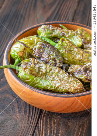 Terracotta bowl of Pimientos de Padron sprinkled with coarse sea salt Terracotta bowl of Pimientos de Padron sprinkled with coarse sea salt 129435645