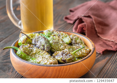 Terracotta bowl of Pimientos de Padron served with cold frothy beer Terracotta bowl of Pimientos de Padron served with cold frothy beer 129435647