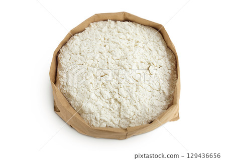 White flour in a paper bag isolated on white background. Top view. Flat lay. White flour in a paper bag isolated on white background. Top view. Flat lay. 129436656