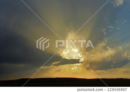 Sun shinging threw the clouds at Sunset out in the country in Kansas Sun shinging threw the clouds at Sunset out in the country in Kansas 129436987