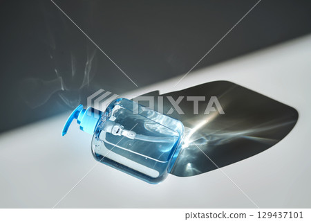 Hand washing gel in a blue bottle with a dispenser on a white background. Hand washing gel in a blue bottle with a dispenser on a white background. 129437101