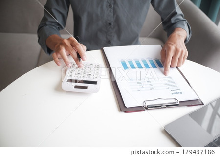 Closeup hand of unrecognisable businessman, accountant, banker working on desk 129437186