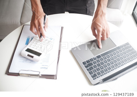 Closeup hand of unrecognisable businessman, accountant, banker working on desk 129437189