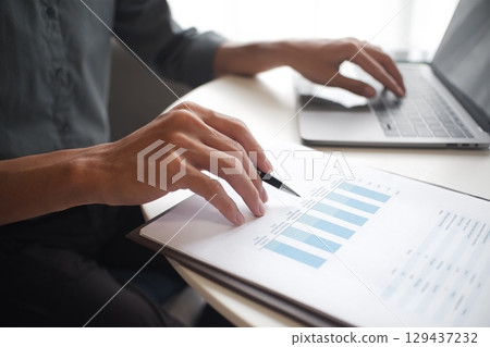 Closeup hand of unrecognisable businessman, accountant, banker working on desk at the workplace. 129437232