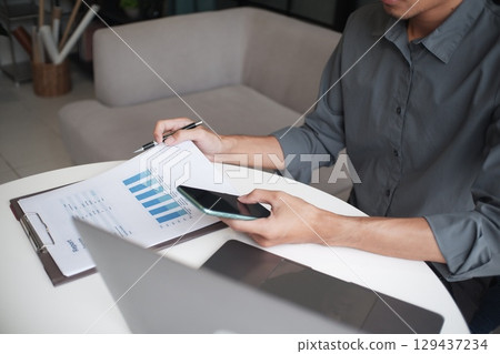 Closeup hand of unrecognisable businessman, accountant, banker working on desk at the workplace. 129437234