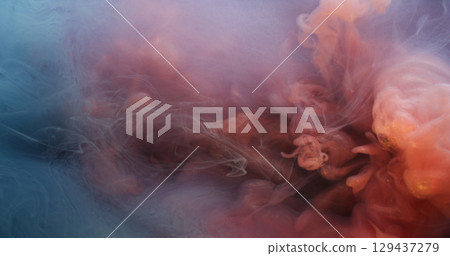 Fume water. Cloud vapor. Defocused orange pink blue color ink swirling liquid drop floating on abstract underwater acrylic art background. 129437279