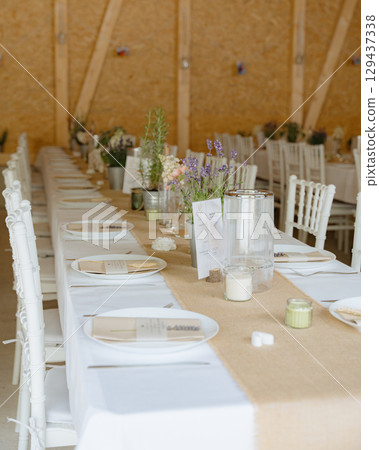 Beautiful wedding table arrangement with lavender details, rustic textures, and natural tones. Perfect for invitations, blogs, and event inspiration. 129437338
