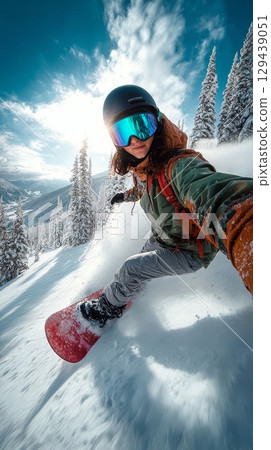 Woman snowboarder carving down a snowy mountain slope winter wonderland action shot outdoor adventure dynamic viewpoint 129439051