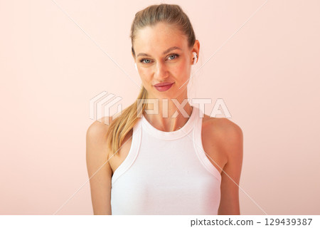 Portrait of a young woman listening to music with wireless earbuds 129439387