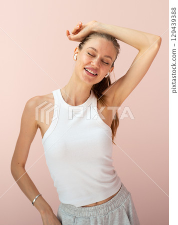 Young woman listening to music, smiling with eyes closed Young woman listening to music, smiling with eyes closed 129439388
