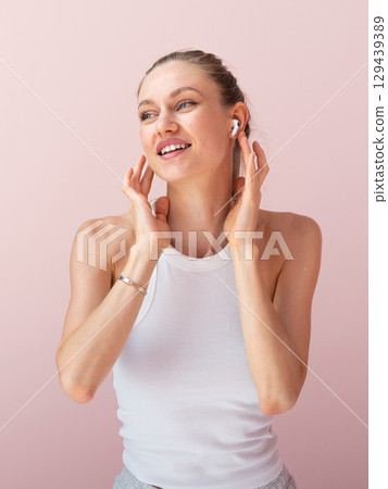 Smiling woman in earbuds feeling the rhythm of music Smiling woman in earbuds feeling the rhythm of music 129439389