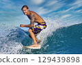 Male surfer on a blue wave 129439898