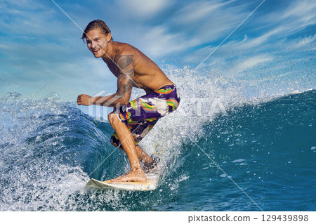 Male surfer on a blue wave 129439898