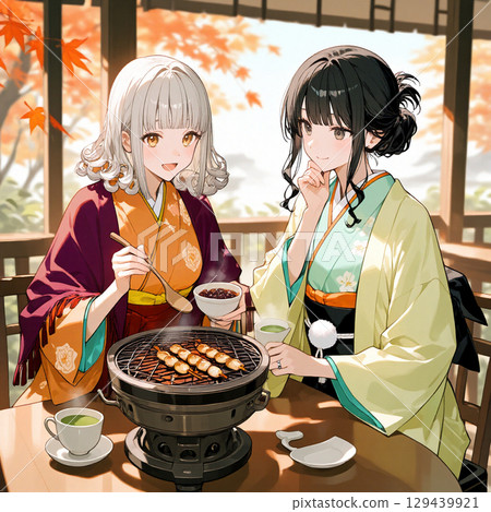 Two women roasting dumplings on a charcoal grill with autumn leaves in the background 129439921