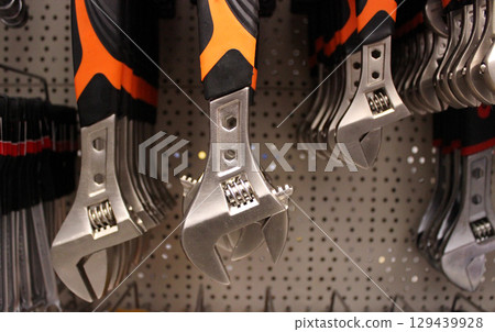 Colored grip adjustable wrenches on the shelf at hardware shop 129439928