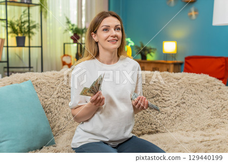 Pregnant woman counts dollars cash planning baby birth budget serious money management preparation 129440199