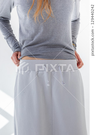 Beautiful woman in gray skirt and T-shirt on white background. Fashionable female style. Studio photography. Vertical photo. High quality photo Beautiful woman in gray skirt and T-shirt on white background. Fashionable female style. Studio photography. Vertical photo. High quality photo 129440242