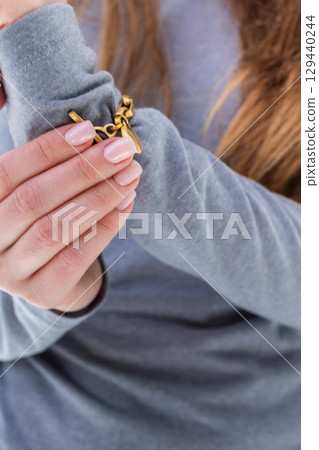 Woman fastening bracelet on hand close-up. Vertical photo. High quality photo Woman fastening bracelet on hand close-up. Vertical photo. High quality photo 129440244
